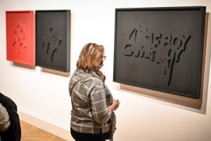 kobieta oglądającą pracę prezentującą napis "Gameboy"