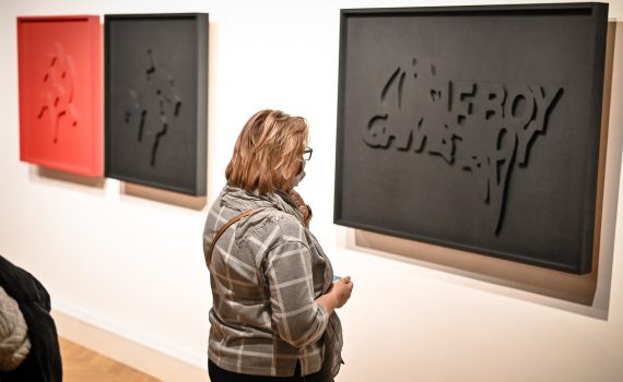 kobieta oglądającą pracę prezentującą napis "Gameboy"