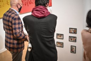 dwaj mężczyźni stojący tyłem oglądający wystawę