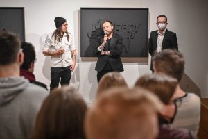 Łukasz Gawron Jan Sętowski Robert Jasiak stojący przed publicznością podczas wernisażu wystawy