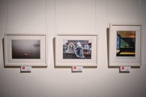 trzy oprawione w ramy fotografie wiszące na ścianie w galerii sztuki