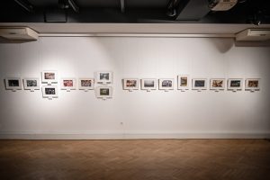 rząd fotografii na ścianie w galerii sztuki