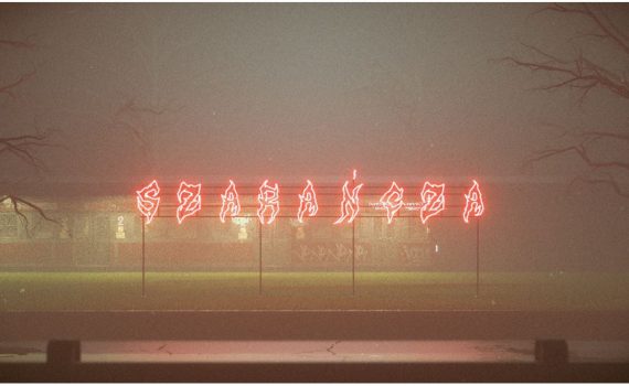 stacja kolejowa z czerwonym neonem z napisem "Szarańcza"