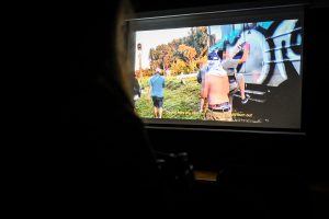 ekran wyświetlający film w stopklatce grafficiarze malujący pociąg