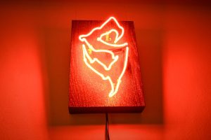 czerwony neon przedstawiający zniekształconą literę "S"