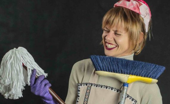 uśmiechnięta kobieta ze szczotką i mopem w rękach