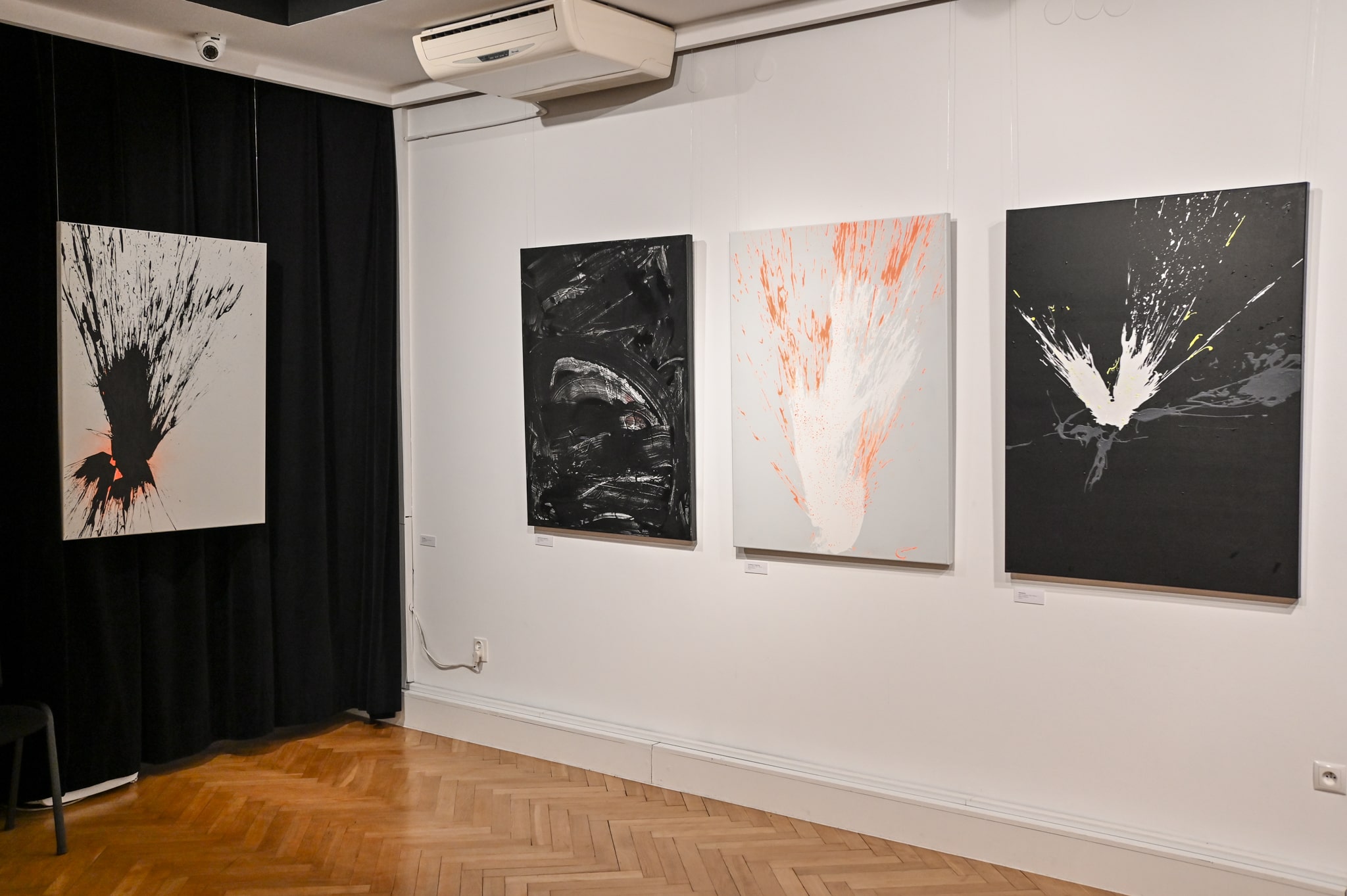 obrazy malarskie Łukasza Chmielewskiego zawieszone na ścianie w galerii sztuki
