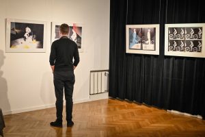 mężczyzna oglądający obrazy w galerii sztuki