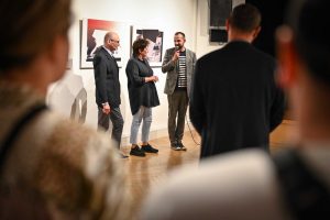 Robert Jasiak dyrektor Ośrodka Promocji Kultury Gaude Mater w Częstochowie witający publiczność podczas wernisażu wystawy w instytucji po jego prawej kolejno stoi Anna Szumigaj-Badziak artystka i Robert Sękiewicz kurator