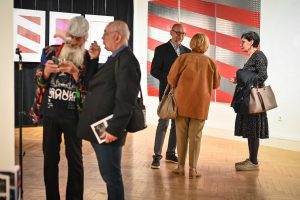 osoby rozmawiające w galerii sztuki