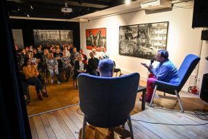 spotkanie autorskie w Ośrodku Promocji Kultury w Częstochowie publiczność przed sceną autor i prowadzący na scenie