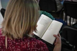 kobieta czytająca wiersz pochodzący z książki Marcina Zegadło zatytułowanej Martwe i Ozdobne