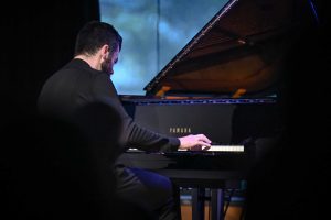 Łukasz Ojdana grający na fortepianie