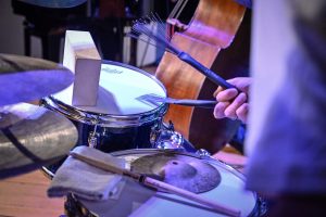 perkusista grający na perkusji miotełkami perkusyjnymi