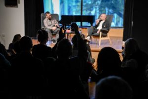 osoba z publiczności wykonująca fotografię telefonem komórkowym podczas spotkania autorskiego