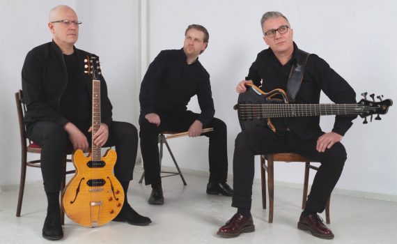 Formacja Adam Golicki Trio muzycy siedzący na krzesłach i trzymający swoje instrumenty