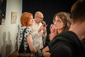 Robert Sękiewicz, kurator galerii Ośrodka Promocji Kultury Gaude Mater w Częstochowie rozmawiający z publicznością podczas wernisażu wystawy w instytucji