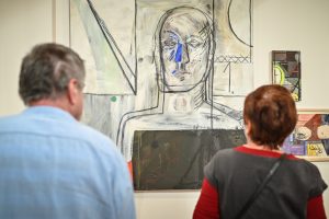mężczyzna i kobieta odwróceni tyłem oglądający obraz malarski autorstwa Antoniny Janus-Szybist
