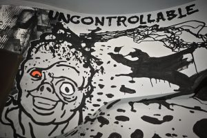 fragment muralu Bartłomieja Stypki zawierający napis w języku angielskim z wyrazem: UNCONTROLLABLE