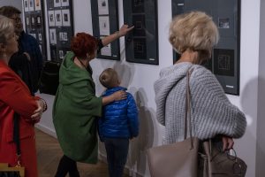 kobieta pokazująca chłopczykowi obraz na wystawie w galerii sztuki