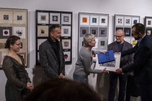 Robert Jasiak wręczający nagrody laureatce międzynarodowego biennale miniatury