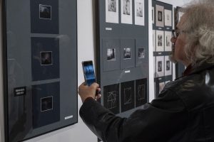 mężczyzna wykonujący zdjęcie ekspozycji prac w galerii sztuki