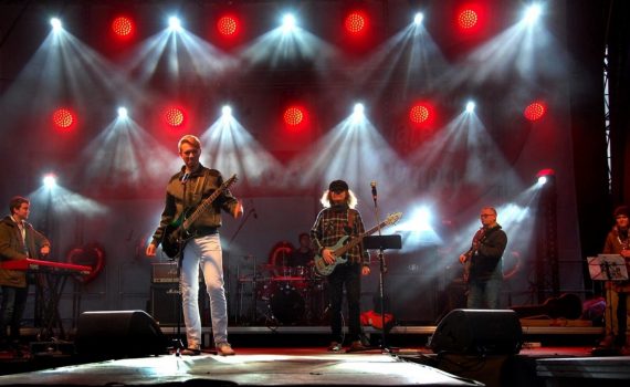 Zespół PasiBrzuchy na scenie, w tle światła białe i czerwone.