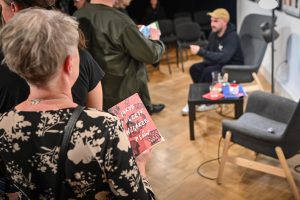 kobieta stojąca z książką Jakuba Żulczyka Wzgórze psów w kolejce po autograf autora