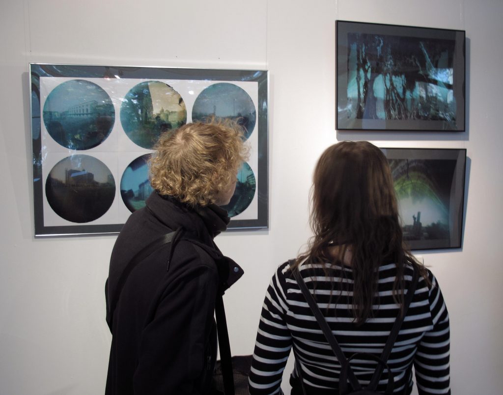 dwoje ludzi oglądających fotografie na wystawie artystycznej w galerii sztuki