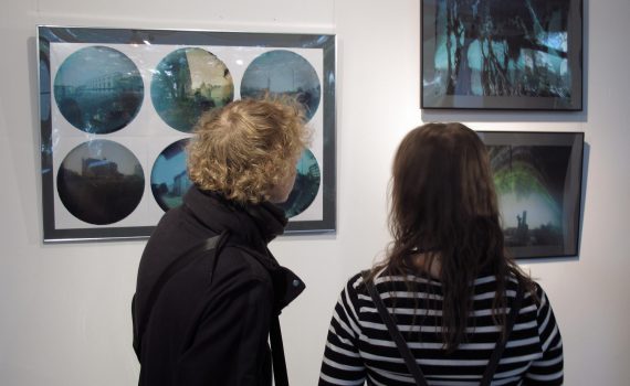 dwoje ludzi oglądających fotografie na wystawie artystycznej w galerii sztuki