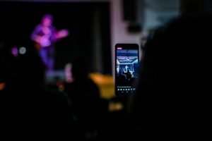 telefon wyświetlający tramisję na żywo koncertu philipa brackena