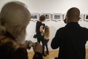 kobieta z dziewczynką przyglądające się fotografiom na wystawie sztuki