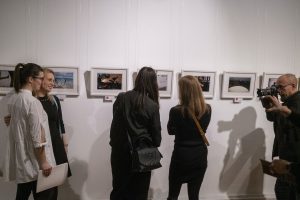 kobiety pozujące do zdjęcia przed fotografem podczas wernisażu wystawy