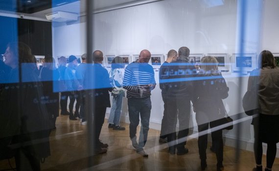 publiczność oglądająca wystawę fotografii w galerii sztuki