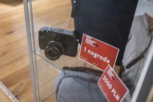 aparat fotograficzny i dwie karty każda z napisem kolejno 1 nagroda 2000 pln