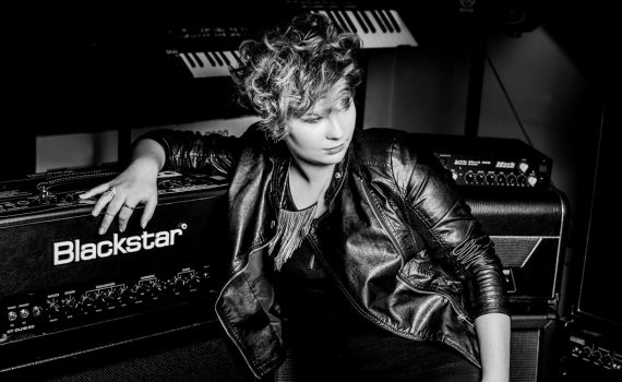 czarno-biała fotografia przedstawiająca igę kozacką siedzącą przy sprzęcie muzycznym