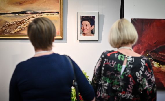 w tle fotografia Agnieszki Kwapisz-Wolbiś zawieszona na ścianie