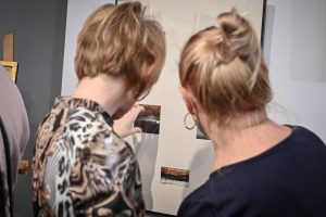 dwie kobiety oglądające obraz podczas wystawy