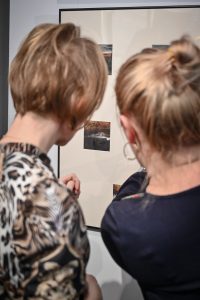 dwie kobiety oglądające prace w galerii sztuki