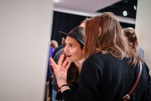 kobiety przyglądające się obrazom na wystawie sztuki