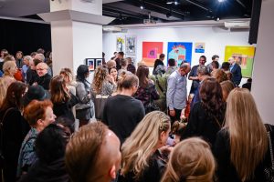 publiczność zebrana na wernisażu wystawy w galerii sztuki