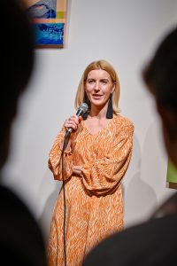 Justyna Warwas witająca publiczność na wernisażu wystawy