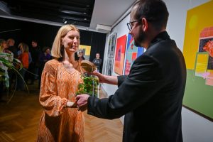 Justyna Warwas odbierająca prezent od Roberta Jasiak podczas wernisażu wystawy