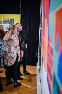 publiczność przyglądająca się wystawie sztuki