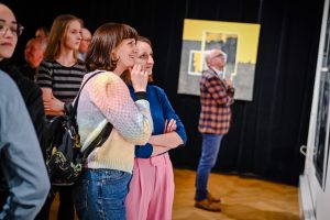 kobiety przyglądające się ekspozycji na wystawie sztuki