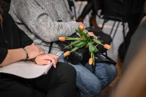 kobieta trzymająca kwiaty położone na kolanach