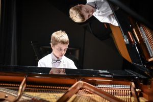 młody chłopiec przy fortepianie