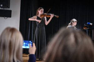 młoda kobieta grająca na skrzypcach na scenie